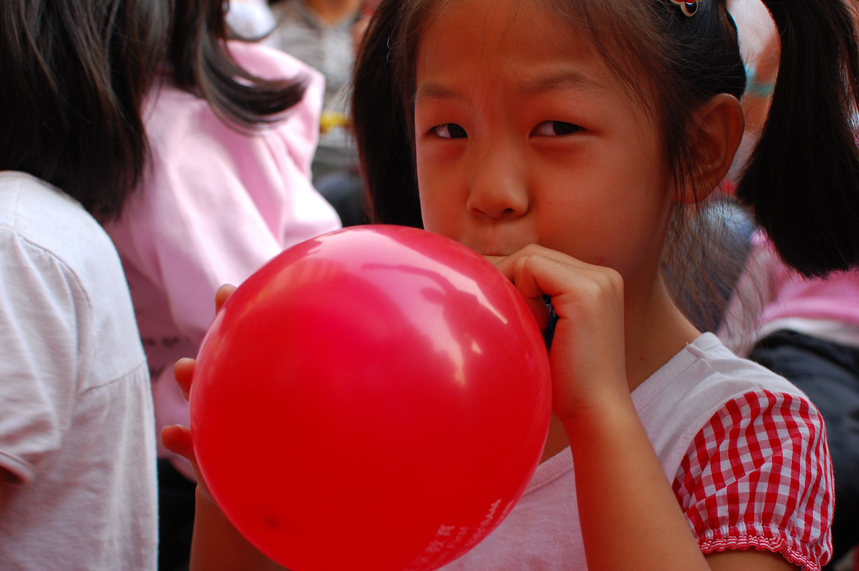 Girl_inflating_a_red_balloon